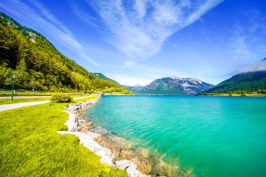 Tyrol 'daki Achensee Gölü manzarası. Turkuaz göldeki doğa ve arka planda bir dağ manzarası. Avusturya 'da Achental.