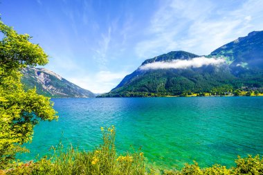 Tyrol 'daki Achensee Gölü manzarası. Turkuaz göldeki doğa ve arka planda bir dağ manzarası. Avusturya 'da Achental.