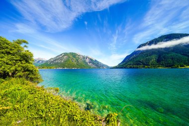 Tyrol 'daki Achensee Gölü manzarası. Turkuaz göldeki doğa ve arka planda bir dağ manzarası. Avusturya 'da Achental.