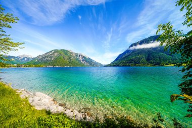 Tyrol 'daki Achensee Gölü manzarası. Turkuaz göldeki doğa ve arka planda bir dağ manzarası. Avusturya 'da Achental.