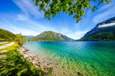 Tyrol 'daki Achensee Gölü manzarası. Turkuaz göldeki doğa ve arka planda bir dağ manzarası. Avusturya 'da Achental.