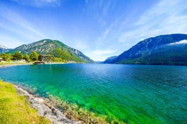 Tyrol 'daki Achensee Gölü manzarası. Turkuaz göldeki doğa ve arka planda bir dağ manzarası. Avusturya 'da Achental.