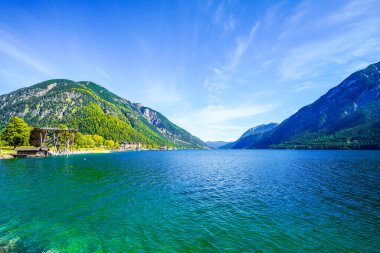 Tyrol 'daki Achensee Gölü manzarası. Turkuaz göldeki doğa ve arka planda bir dağ manzarası. Avusturya 'da Achental.