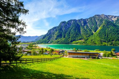 Tyrol 'daki Achensee Gölü manzarası. Turkuaz göldeki doğa ve arka planda bir dağ manzarası. Avusturya 'da Achental.