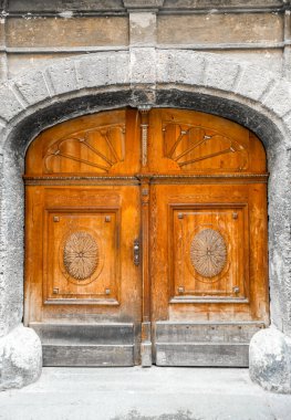 Yuvarlak kemerli ve süslemeli eski ahşap kapı. Kahverengi gri ile geniş kırsal giriş.