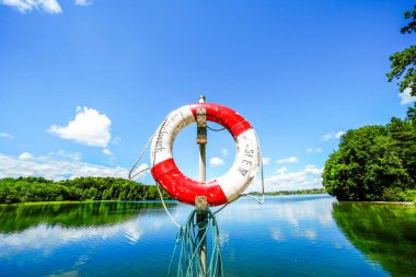 Seehamer 'da kırmızı ve beyaz can simidi. Göl kenarındaki manzara.