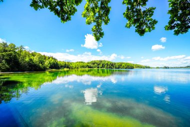 Seehamer See ve Münih yakınlarındaki Weyarn belediyesinin manzarası. Göl kıyısında turkuaz suyla donanımlı bir doğa..