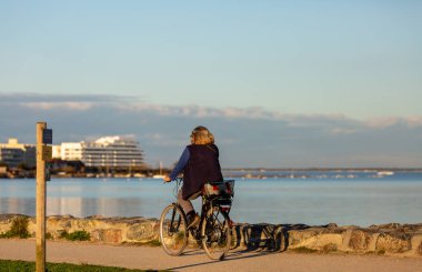Güneşli bir günde bisiklet süren bir insan.