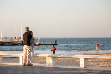 Yaşlı bir çift sahilde geziniyor.