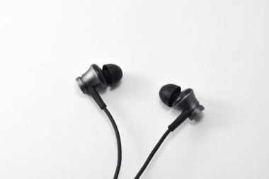 Music earphones. Black stereo audio headphone, electronic personal small portable sound earbud, isolated on white background