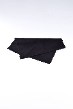 Microfiber cleaning cloth for glasses, or camera lens isolated on white background. Black micro fibre cloth.