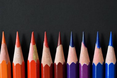 Color pencils with copy space isolated on black paper. Close up