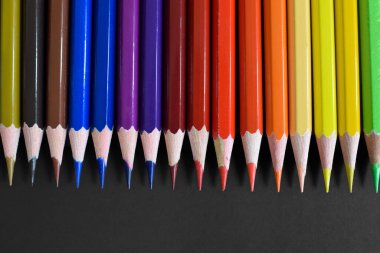Color pencils with copy space isolated on black paper. Close up