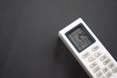 Air conditioner remote on black background. Close up air conditioner 24 degrees celsius