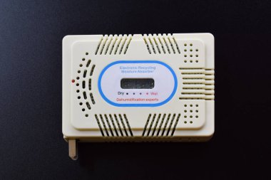 Close up of electronic moisture absorber isolated on black background. Recycling silica gel.