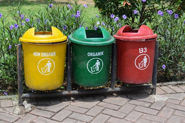 Different colored trash cans in the park. B3 (Hazardous waste), non organic and organic waste suitable for recycling. Segregate waste, sorting garbage, waste management