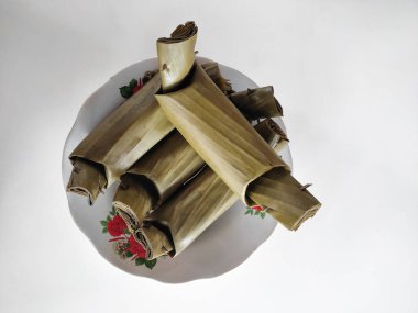 Lontong is an Indonesian dish. wrapped with banana leaves and boiled on white plate