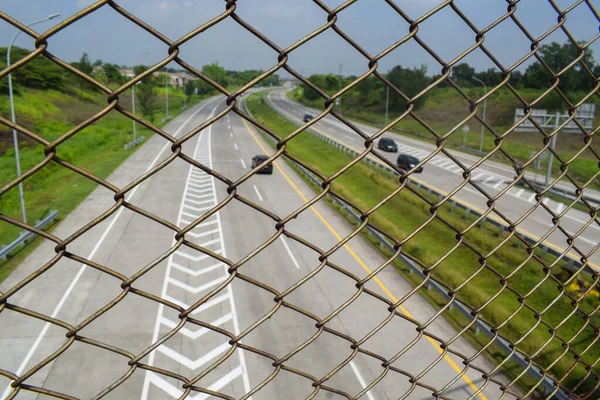 Chain link fence on the highway. as a roadside barrier