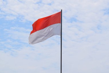 Indonesian Flag, Red and White, waving in the wind with blue sky background