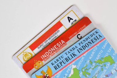 Pasuruan, Indonesia - November 2, 2022 : old SIM A model, new SIM C or Smart SIM (driving license) and KTP (residential card). Isolated on white background