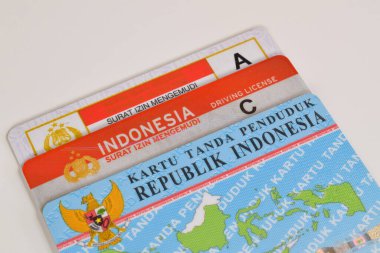 Pasuruan, Indonesia - November 2, 2022 : old SIM A model, new SIM C or Smart SIM (driving license) and KTP (residential card). Isolated on white background