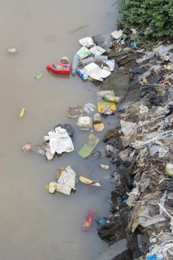 Pasuruan, 26 October 2022 - Plastic bottles, cans, packages and other river waste. Garbage in the River