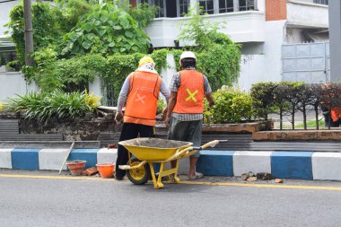 Pasuruan - November 17, 2022 : Workers repairing traffic lane dividers and separators made of concrete on asphalt roads