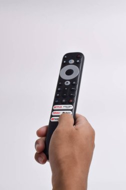 Pasuruan - 22 Şubat 2024: Evde sinema ve eğlence programları için Smart TV yayın kanalı seçimini gösteren uzaktan kumanda (Netflix, Prime Video, Youtube, WeTV, Vidio)