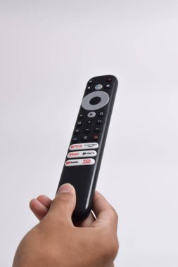 Pasuruan - 22 Şubat 2024: Evde sinema ve eğlence programları için Smart TV yayın kanalı seçimini gösteren uzaktan kumanda (Netflix, Prime Video, Youtube, WeTV, Vidio)