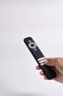 Pasuruan - 22 Şubat 2024: Evde sinema ve eğlence programları için Smart TV yayın kanalı seçimini gösteren uzaktan kumanda (Netflix, Prime Video, Youtube, WeTV, Vidio)