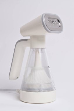 Beyaz arka planda izole edilmiş giysiler için el buharı. Taşınabilir ev ve giysi vapuru.