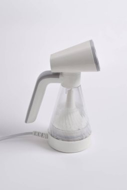 Beyaz arka planda izole edilmiş giysiler için el buharı. Taşınabilir ev ve giysi vapuru.