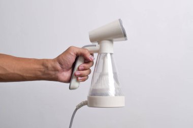 Beyaz arka planda izole edilmiş giysiler için el buharı. Taşınabilir ev ve giysi vapuru.