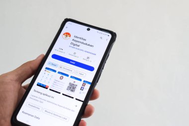 Pasuruan, Endonezya - 2 Mayıs 2024: Ulusal Nüfus Kimliği (IDK) mobil uygulamasına erişen adam. Dijital Nüfus Kimliği (IKD) uygulamasının görüntüsü.