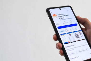 Pasuruan, Endonezya - 2 Mayıs 2024: Ulusal Nüfus Kimliği (IDK) mobil uygulamasına erişen adam. Dijital Nüfus Kimliği (IKD) uygulamasının görüntüsü.