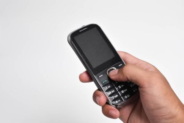 El ele tutuşan eski cep telefonu beyaz arka planda izole edilmiş. Eski cep telefonu