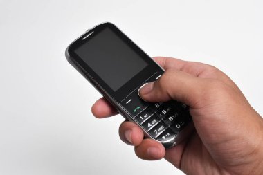 El ele tutuşan eski cep telefonu beyaz arka planda izole edilmiş. Eski cep telefonu