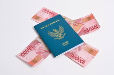 Beyaz arka planda 100.000 rupia 'lık yığınla Endonezya pasaportu.
