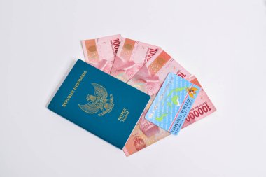 Pasuruan, Endonezya - 2 Mayıs 2024: Endonezya pasaportu ve Endonezya kimlik kartları (KTP) beyaz arka planda 100.000 rupia 'lık banknotların üzerinde