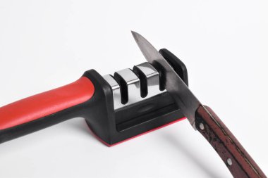 Bıçak ve bıçak keskinleştirici beyaz arka planda izole edilmiş. Elle bıçak bileme, mutfak aletleri.