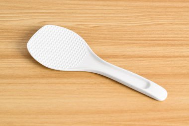 Beyaz pirinç kaşığı ya da tahta masada pirinç kepçesi. Beyaz plastik pirinç küreği