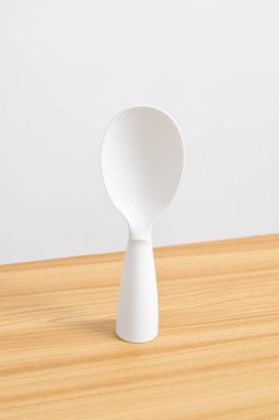 White rice spoon or rice ladle on wooden table. White plastic rice paddle clipart
