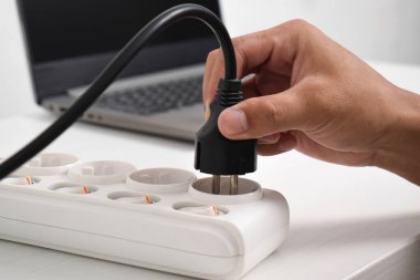 El fişi takılı, prizli çoklu soket. Evdeki prizin prizine elektrik prizi takın. Elektrik prizi, elektrikli ekipman, elektrik kabloları ve elektrik bantları evde.