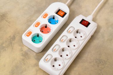 Evdeki prizin prizine beyaz elektrik prizi, güç kablosu, elektrik uzatma kablosu, güç düğmesi ve bağlı bir elektrik prizi.