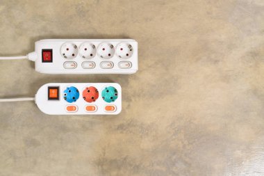 Evdeki prizin prizine beyaz elektrik prizi, güç kablosu, elektrik uzatma kablosu, güç düğmesi ve bağlı bir elektrik prizi.