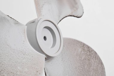 Vantilatör pervanelerindeki kirli tozların havada ve sağlığa karşı alerjisi vardır. Beyaz arka plandaki vantilatörde kirli toz var. seçici odak