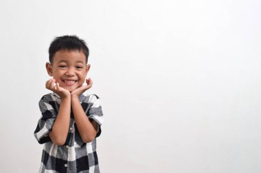 Beyaz arka planda poz veren Asyalı bir çocuk resmi. Güzel pozlar vermiş Asyalı bir çocuğun portresi.