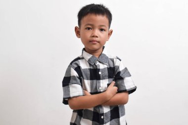 Beyaz arka planda poz veren Asyalı bir çocuk resmi. Asyalı bir çocuğun portresi