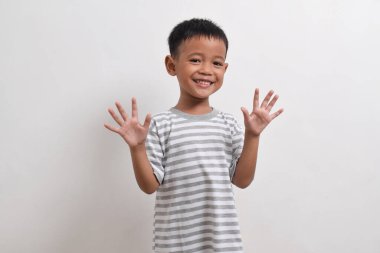 Beyaz arka planda poz veren Asyalı bir çocuk resmi. Asyalı bir çocuğun portresi