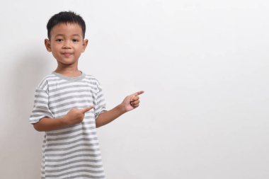 Asyalı bir çocuğun beyaz arka planda iki eliyle poz vermesi. Asyalı bir çocuğun portresi